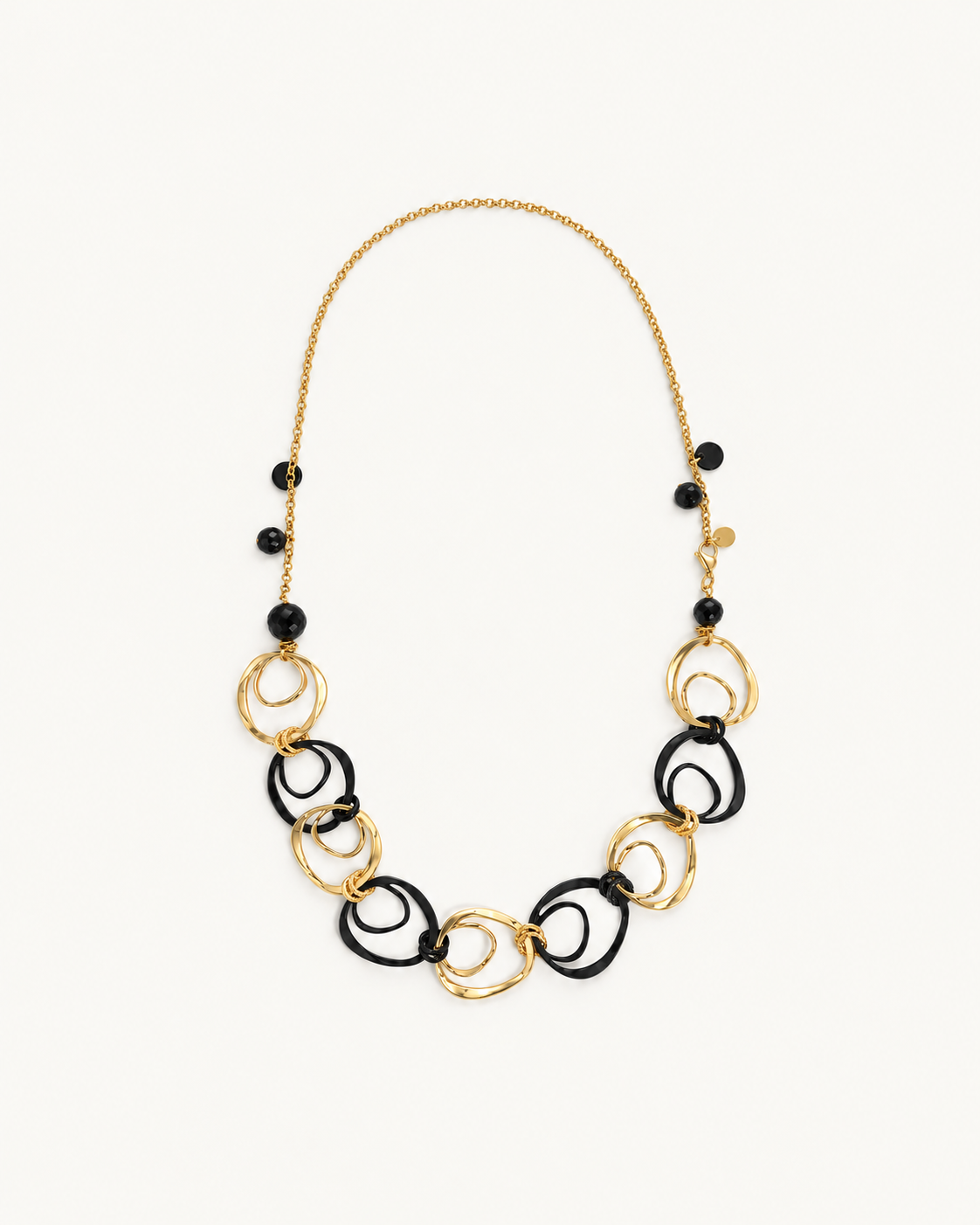Collana Circle ÀLMALA, vista intera con grandi anelli neri e color oro